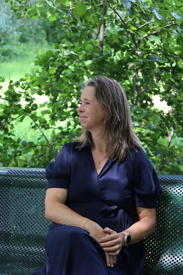 Janny Meijdam op een bankje in het groen